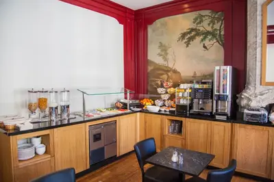 a kitchen with a counter with a table and chairs at Hotel Library Amsterdam in Amsterdam