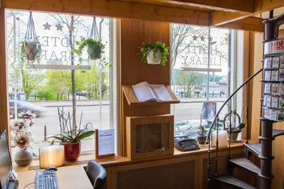 an office with a desk and a window with a book shelf at Hotel Library Amsterdam in Amsterdam