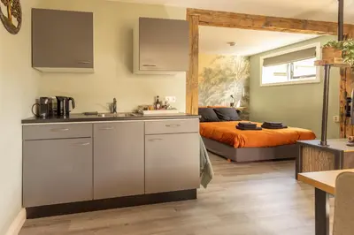 a kitchen and bedroom with a bed in the background at B&B Het Boompje in Wervershoof