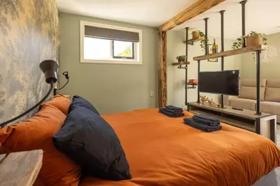 a bedroom with an orange bed and a television at B&B Het Boompje in Wervershoof
