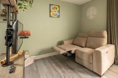 a living room with a couch and a tv at B&B Het Boompje in Wervershoof