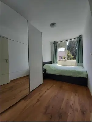 a bedroom with a bed and a large mirror at Villa with garden near Amsterdam in Almere