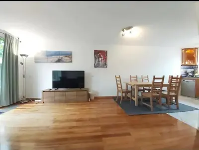 a living room with a table and a television at Villa with garden near Amsterdam in Almere