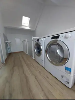 a washer and dryer in a room with a wooden floor at Villa with garden near Amsterdam in Almere
