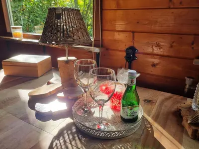 a table with two wine glasses and a lamp at B&B de Prieelhoeve in Almere