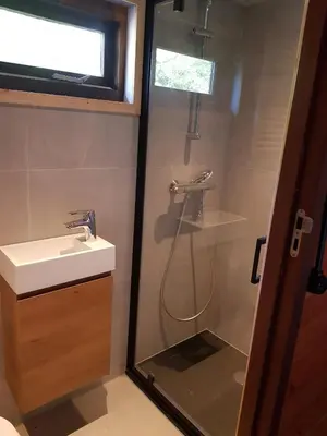 a bathroom with a shower and a sink at B&B de Prieelhoeve in Almere