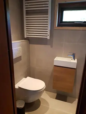 a bathroom with a toilet and a sink and a window at B&B de Prieelhoeve in Almere