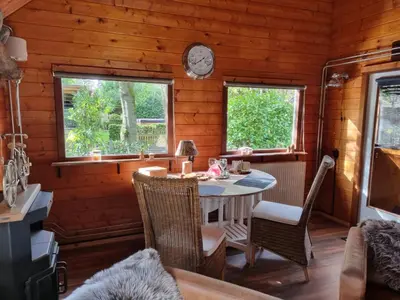 a dining room with a table and two windows at B&B de Prieelhoeve in Almere
