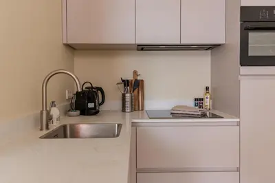a kitchen with white cabinets and a sink at City & Trainhouse in Alkmaar