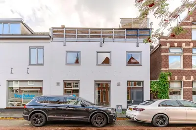 two cars parked in front of a white building at City & Trainhouse in Alkmaar