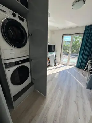 a kitchen with a washer and dryer in a room at Family home Amsterdam Zuid - South in Amsterdam