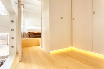 a bedroom with white walls and a wooden floor at Voldersgracht Canal Home Haarlem in Haarlem