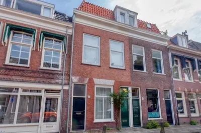a red brick building with white windows on a street at Voldersgracht Canal Home Haarlem in Haarlem