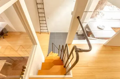a winding staircase in a house with a window at Voldersgracht Canal Home Haarlem in Haarlem