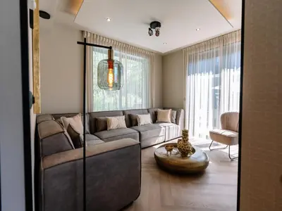 a living room with a couch and a table at Stay with Private Pool & Hot Tub in Waarland