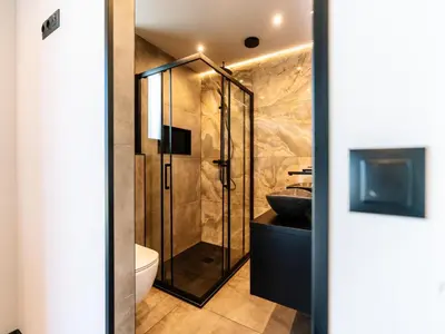 a bathroom with a shower with a sink and a toilet at Stay with Private Pool & Hot Tub in Waarland