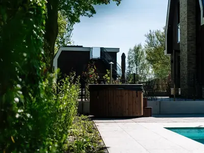 a garden with a large planter in front of a house at Stay with Private Pool & Hot Tub in Waarland
