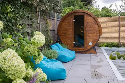 a garden with blue bean bags in front of a barrel at De Aanbouw van Foonloos - luxe studio vlakbij Utrecht in Houten
