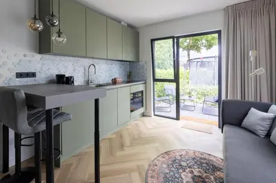 a kitchen and living room with a table and a couch at De Aanbouw van Foonloos - luxe studio vlakbij Utrecht in Houten