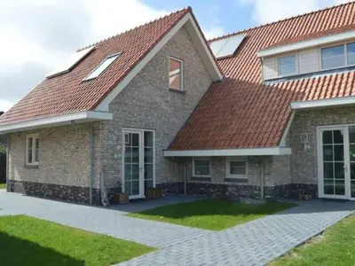 a brick house with a red roof at Waddengoud in Ons Belang