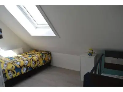 a attic bedroom with a bed and a window at Waddengoud in Ons Belang