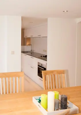 a kitchen with a wooden table with two chairs and a dining room at Casa Del Cisne in Zandvoort