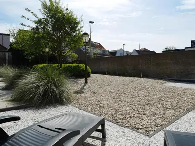 a garden with a bench and a brick wall at Casa Del Cisne in Zandvoort