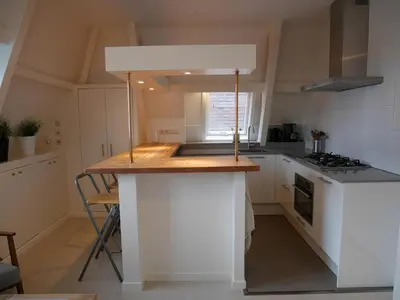 a kitchen with a white island in a room at Casa Del Cisne in Zandvoort
