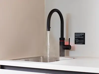 a kitchen sink with water coming out of a faucet at Numa Amsterdam Vondelpark in Amsterdam