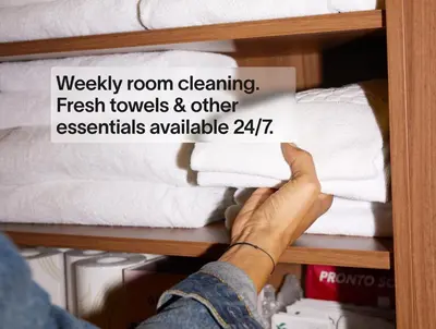 a person holding a sign on a shelf with towels at Numa Amsterdam Vondelpark in Amsterdam