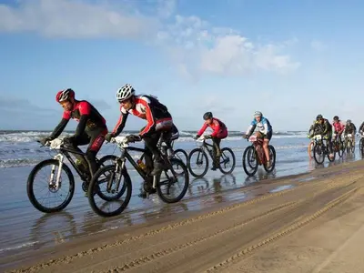 a group of people riding bikes on the beach at Apartment in Zandvoort with swimming pool in Zandvoort