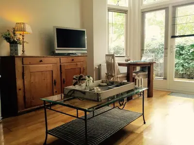 a living room with a glass table and a tv at Apartment in Zandvoort with swimming pool in Zandvoort