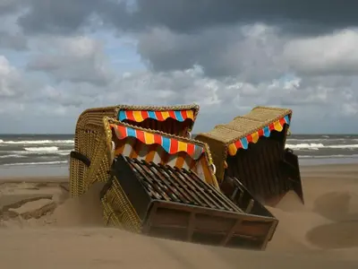 two beach chairs sitting in the sand on the beach at Centraal aan Zee in Egmond aan Zee