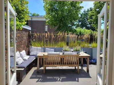 a patio with a wooden bench and a table at Apartment in Naarden with swimming pool in Naarden