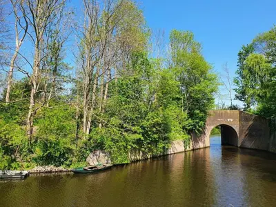 a bridge over a river with a boat in the water at Apartment in Naarden with swimming pool in Naarden