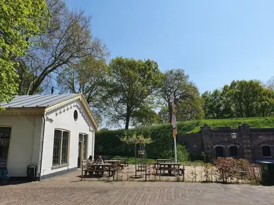 a group of people sitting at a table outside a building at Apartment in Naarden with swimming pool in Naarden