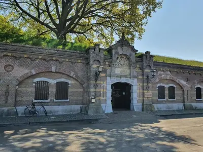 an old brick building with a doorway and a tree at Apartment in Naarden with swimming pool in Naarden