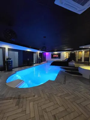 a large swimming pool in a building at night at Bed & Wellness Malina deluxe in Lelystad