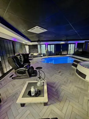 a living room with a pool and a table at Bed & Wellness Malina deluxe in Lelystad