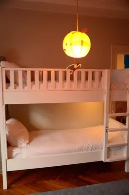 a white bunk bed in a room with a lamp at Entire home with direct Vondelpark view in Amsterdam