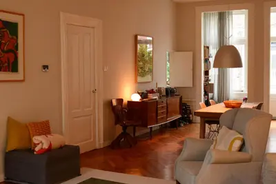 a living room with a table and chairs at Entire home with direct Vondelpark view in Amsterdam