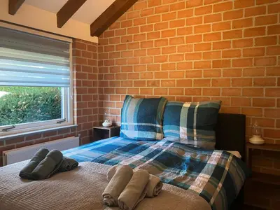a bedroom with a bed and a brick wall at Ferienhaus Sunny's Place in Egmond aan den Hoef