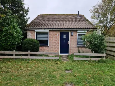 a small brick house with a blue door at Ferienhaus Sunny's Place in Egmond aan den Hoef