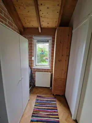 an attic room with a window and a rug at Ferienhaus Sunny's Place in Egmond aan den Hoef