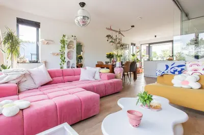 a living room with a pink couch and a table at Villa Lollipop, Amsterdam North in Amsterdam