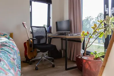 a bedroom with a desk with a computer and a guitar at Villa Lollipop, Amsterdam North in Amsterdam