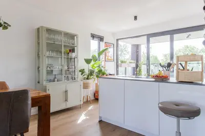 a kitchen with white cabinets and a wooden table at Villa Lollipop, Amsterdam North in Amsterdam
