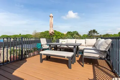 a deck with a table and chairs and an umbrella at Villa Lollipop, Amsterdam North in Amsterdam