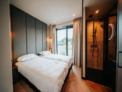 a bedroom with two beds and a large window at Beautiful holiday home in Waarland in Waarland