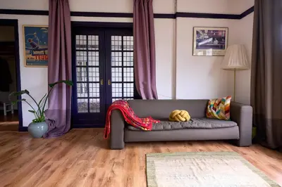 a living room with a couch with a blanket on it at Olympic's Little Palace in Amsterdam